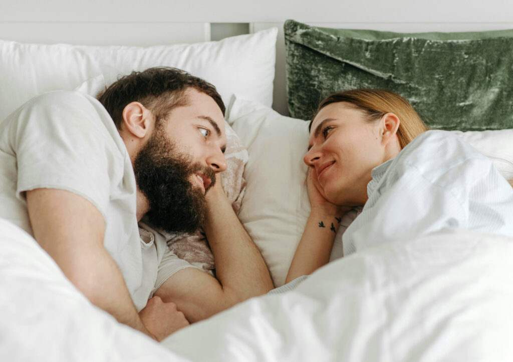 Couple laying in bed, facing eachother, and having a conversation about Core Desires