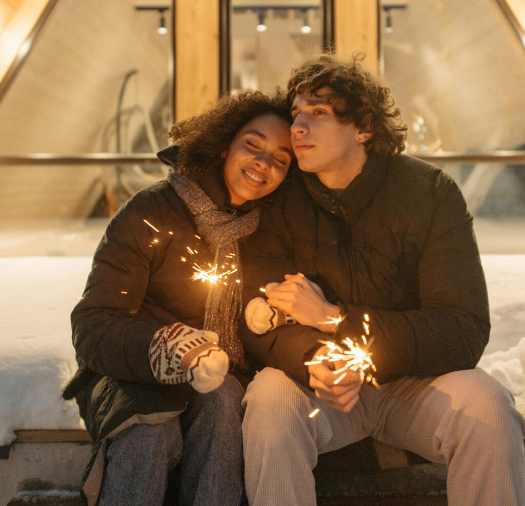 Couple cuddle outside in the snow, having a conversation about core desies