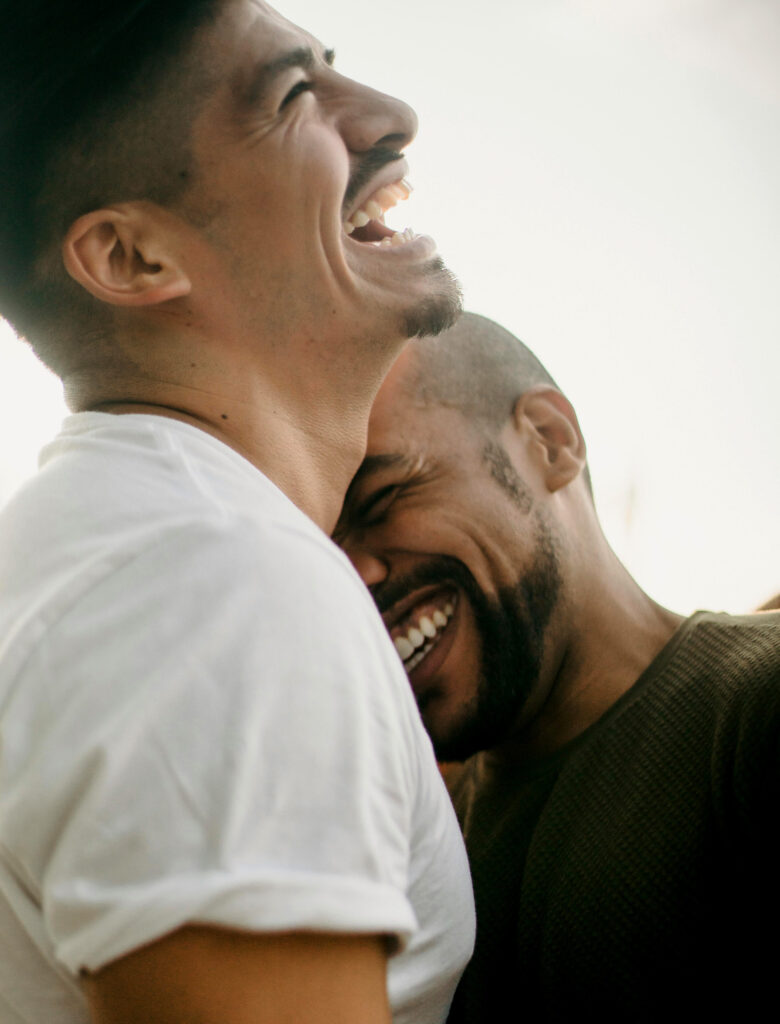 Laughing gay couple, being vulnerable with eachother