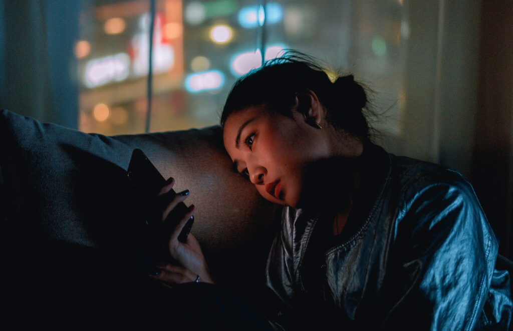 Woman being hyper-attuned to texts on her mobile phone - one of her core protective strategies