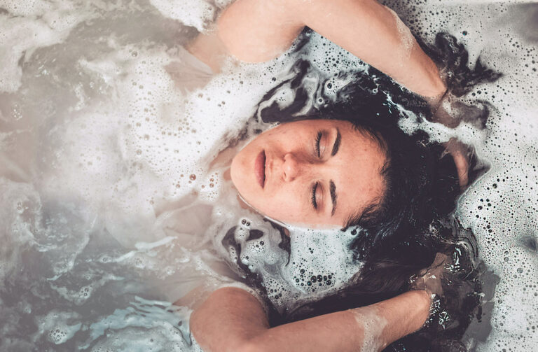 Woman in bath, thinking about her core childhood wounds