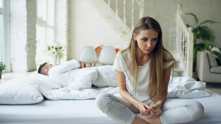 Woman sitting on bed, contemplating her core strategies